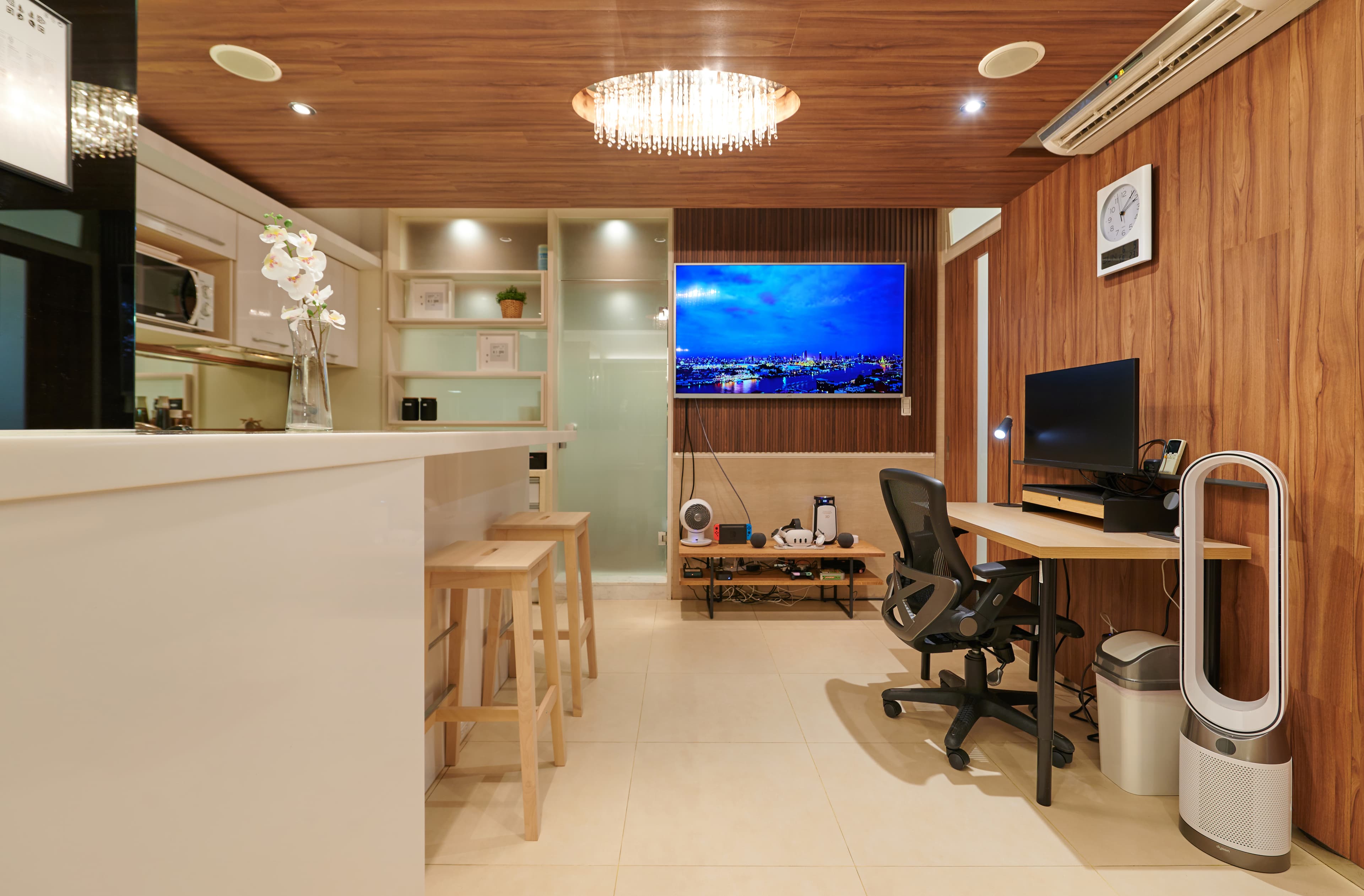 Open-plan Taipei apartment with kitchen island, television, and dedicated workspace